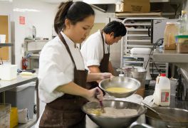 Maree gets tips on plating from Chef Daniel Corey.